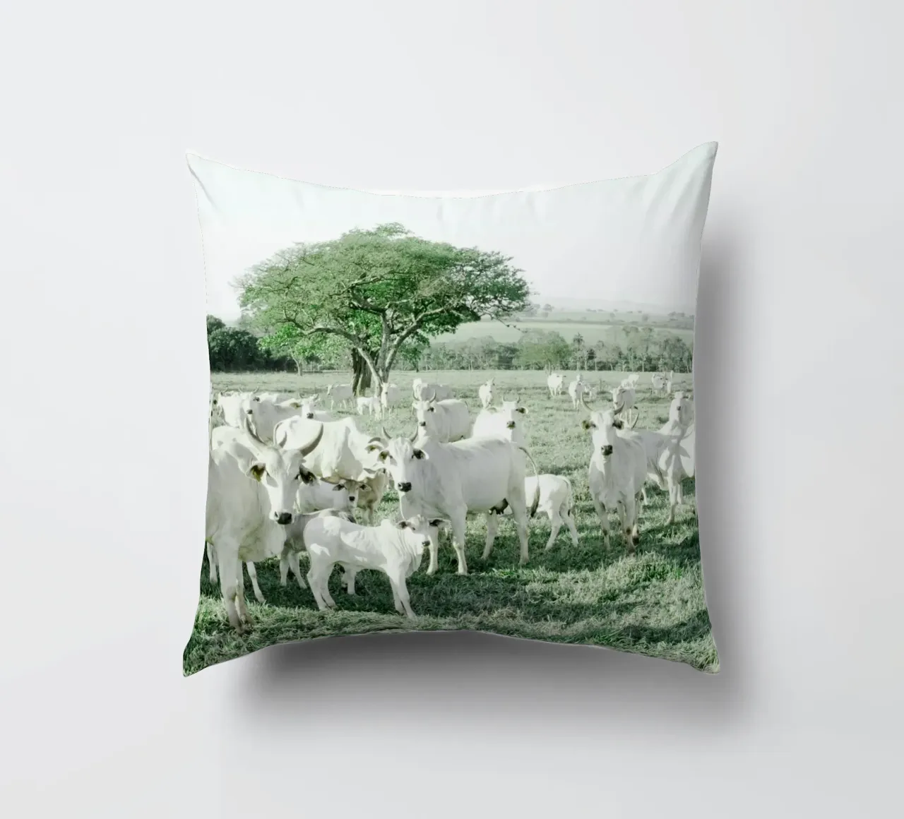 Mucche bianche in un campo verde cuscino da KISSA STUDIO