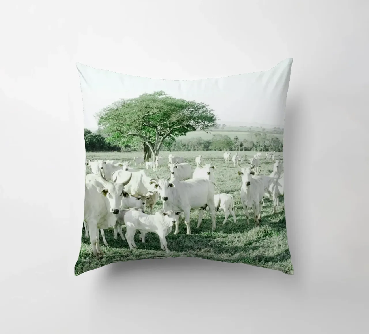 Mucche bianche in un campo verde cuscino da KISSA STUDIO