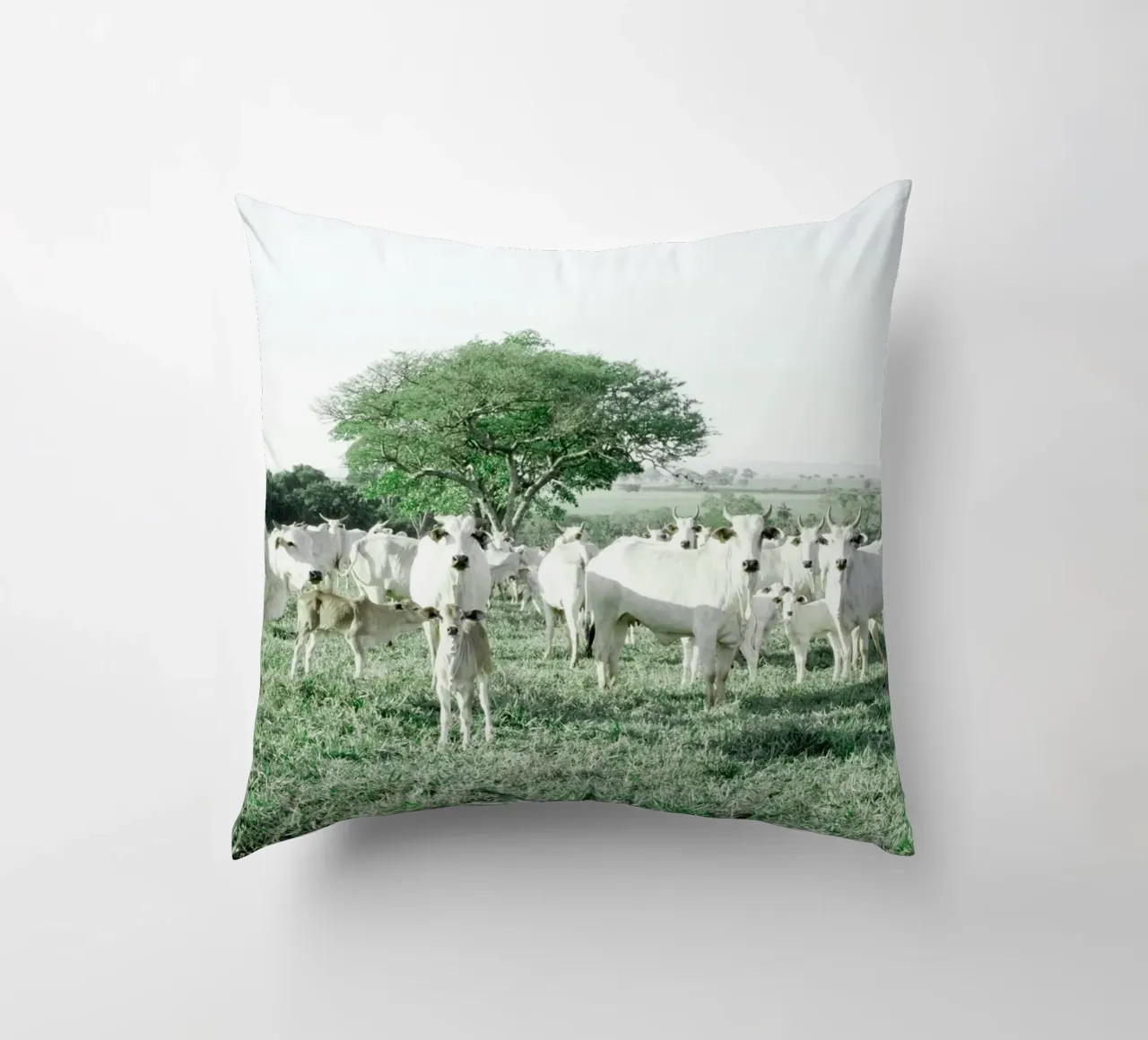 Mucche bianche in un campo verde cuscino da KISSA STUDIO