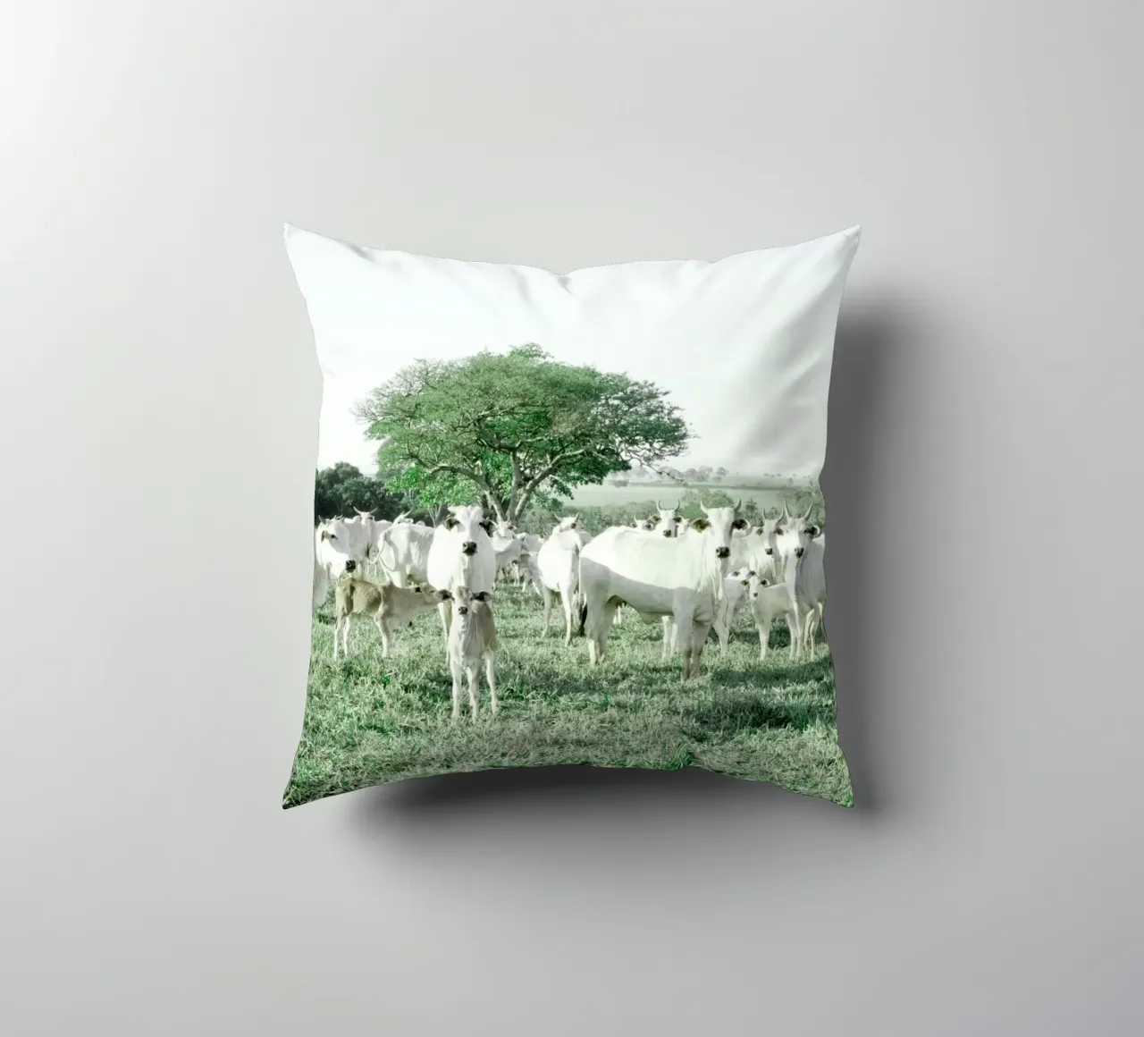 Mucche bianche in un campo verde cuscino da KISSA STUDIO