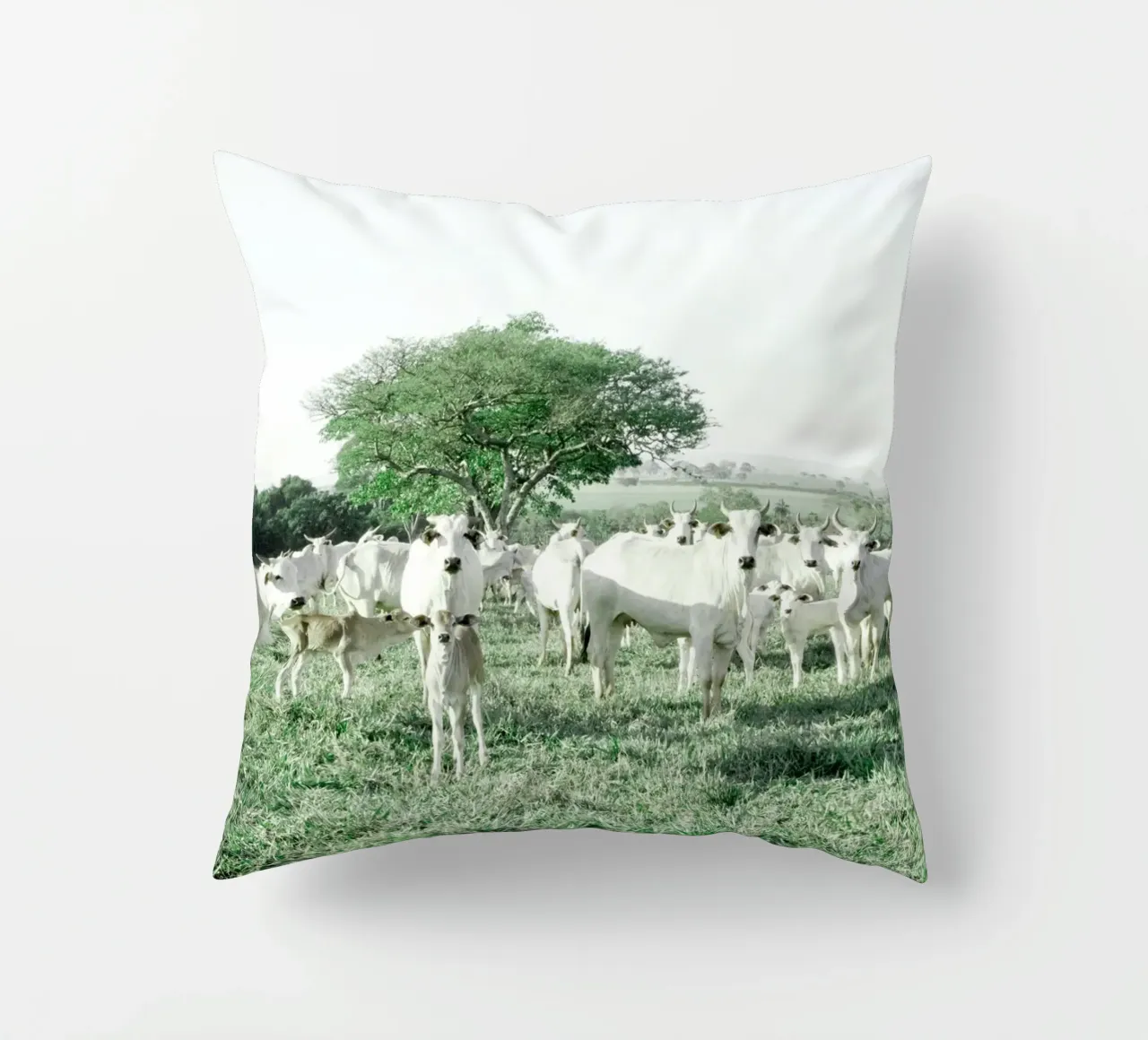 Mucche bianche in un campo verde cuscino da KISSA STUDIO