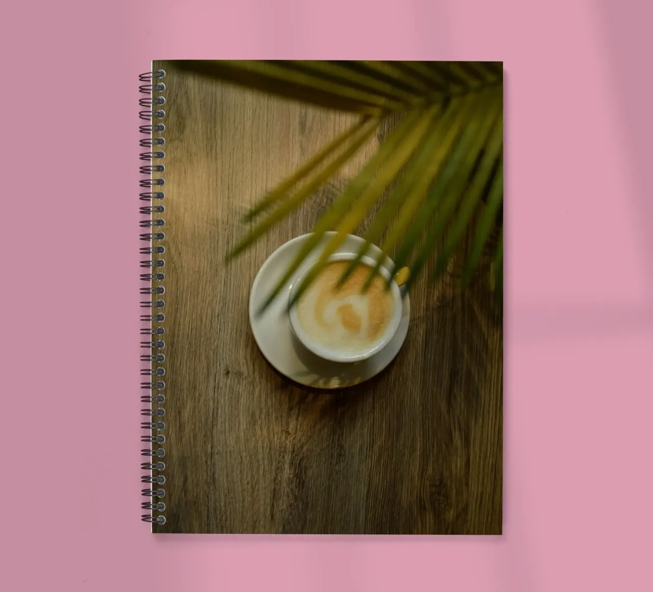 latte art coffee under leave spiral notebook by cofa home