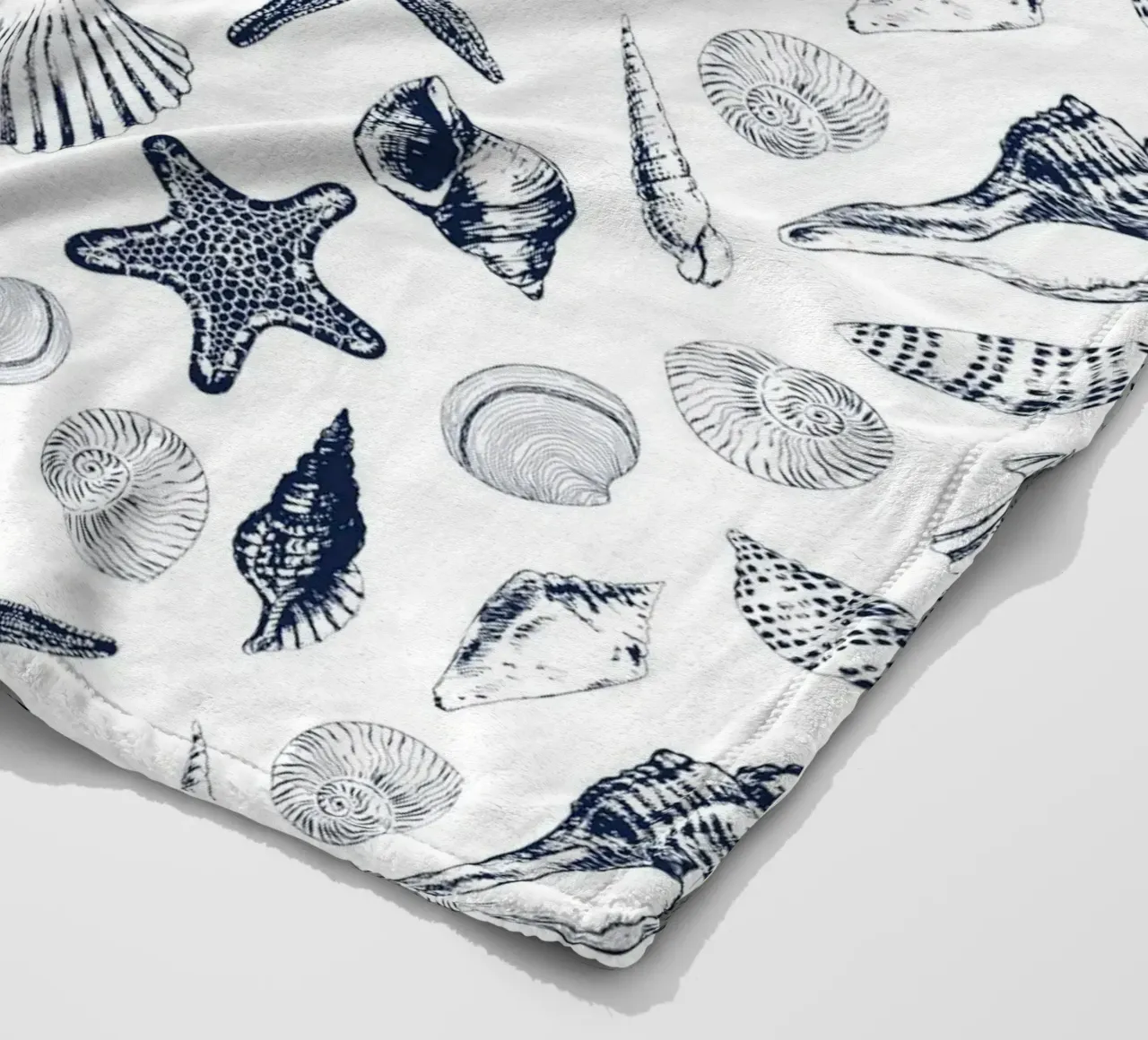Sea shells in navy fleece blanket by Painted Nature