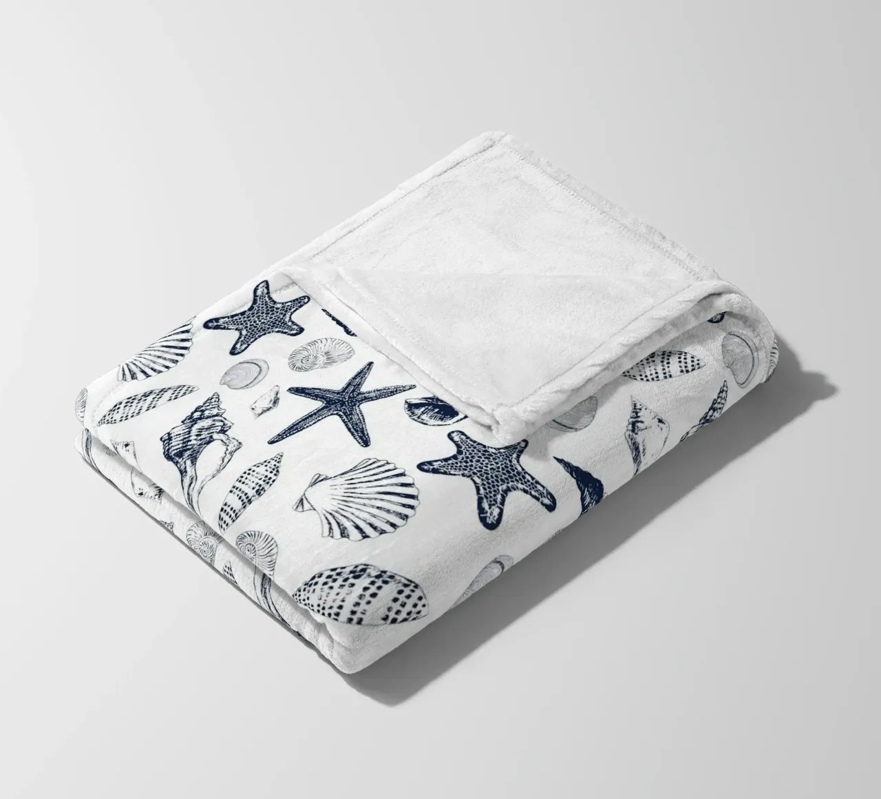 Sea shells in navy fleece blanket by Painted Nature
