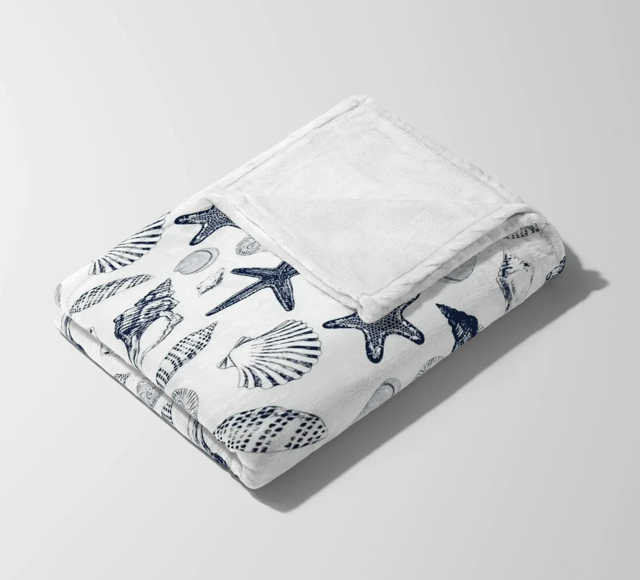 Sea shells in navy fleece blanket by Painted Nature