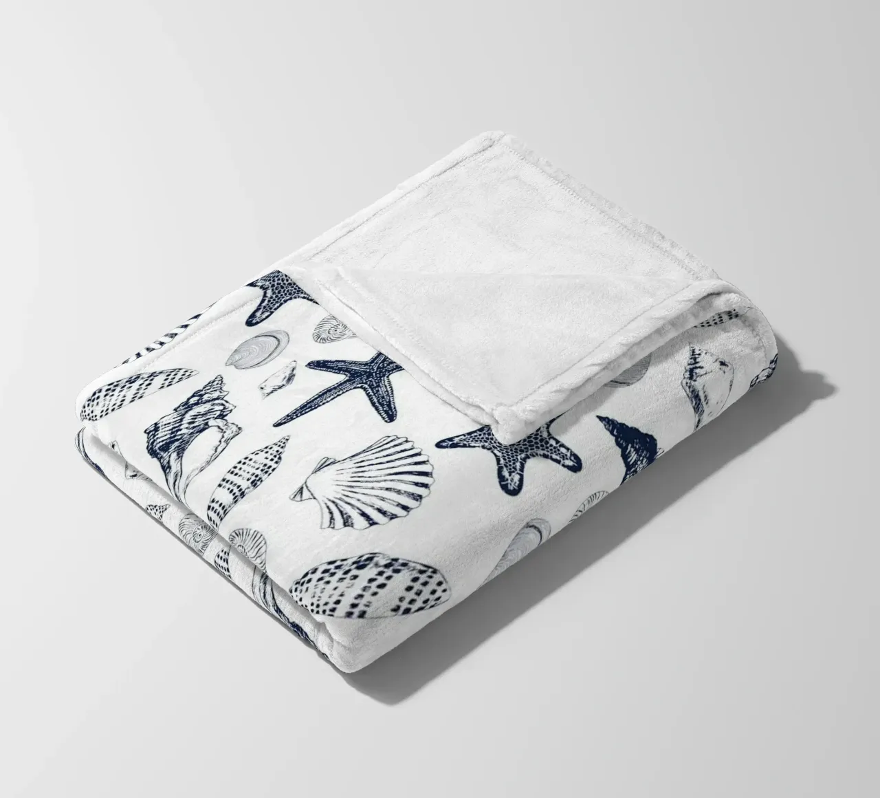 Sea shells in navy fleece blanket by Painted Nature