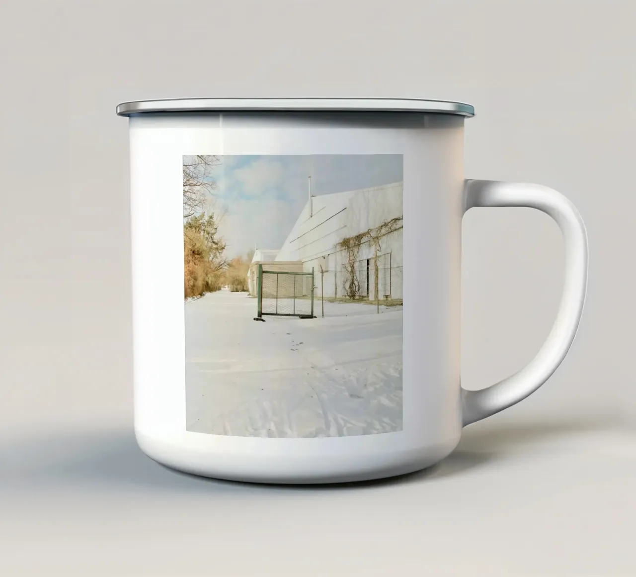 Recinzione in una giornata di sole dopo la neve tazza in smalto da KISSA STUDIO