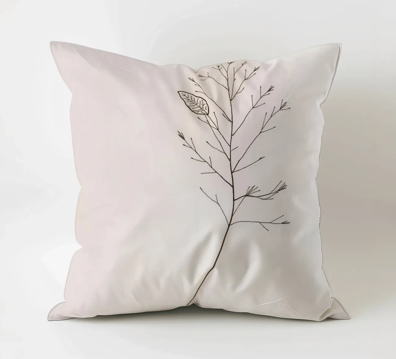 Single minimal botanical branch, displaying a leaf decorative cushion by DesignDoodle