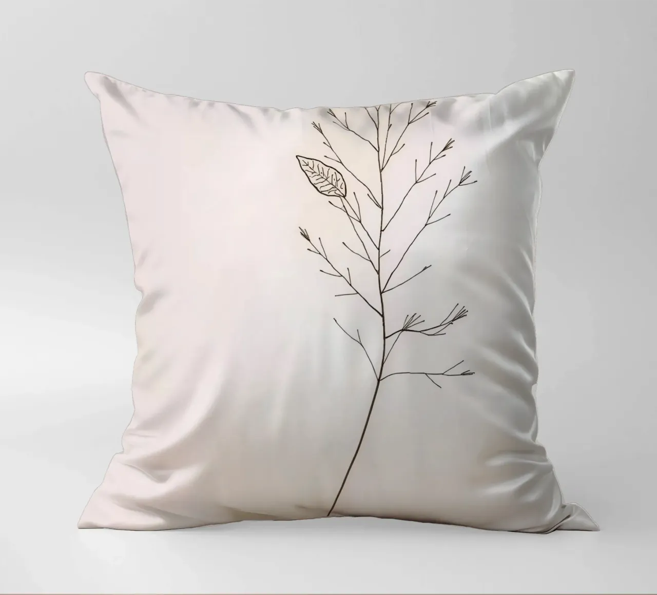 Single minimal botanical branch, displaying a leaf decorative cushion by DesignDoodle