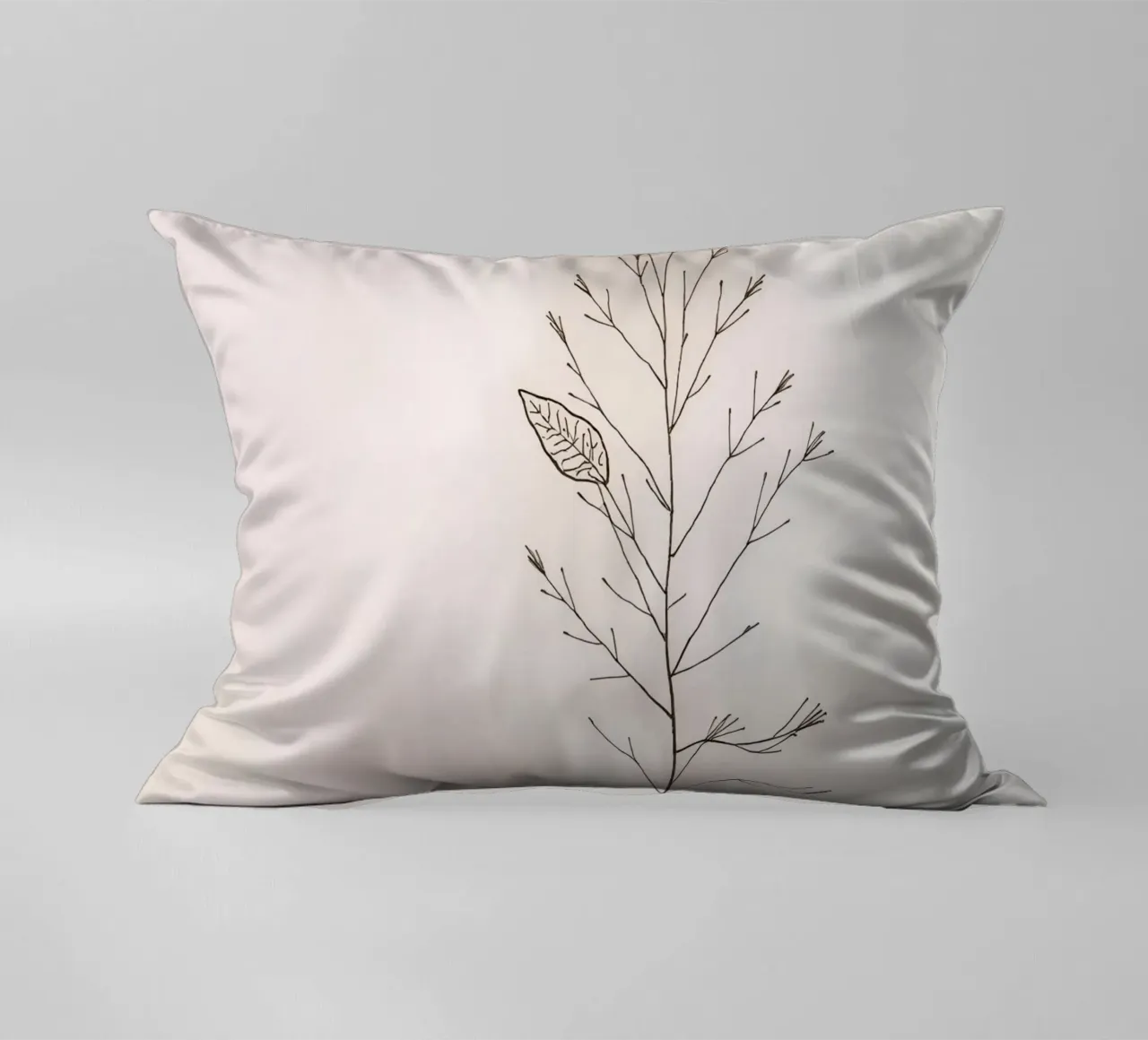 Single minimal botanical branch, displaying a leaf decorative cushion by DesignDoodle