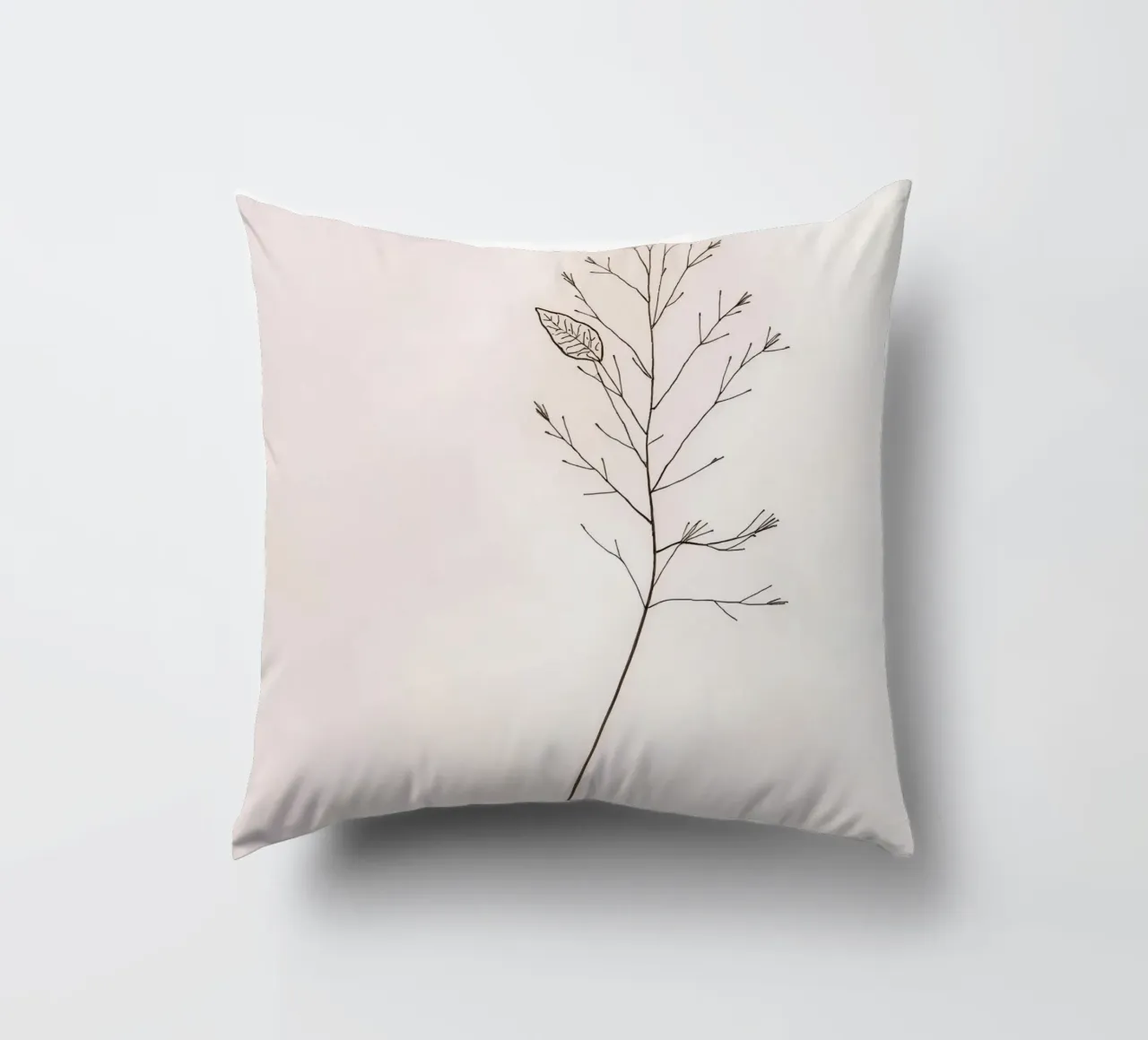 Single minimal botanical branch, displaying a leaf decorative cushion by DesignDoodle