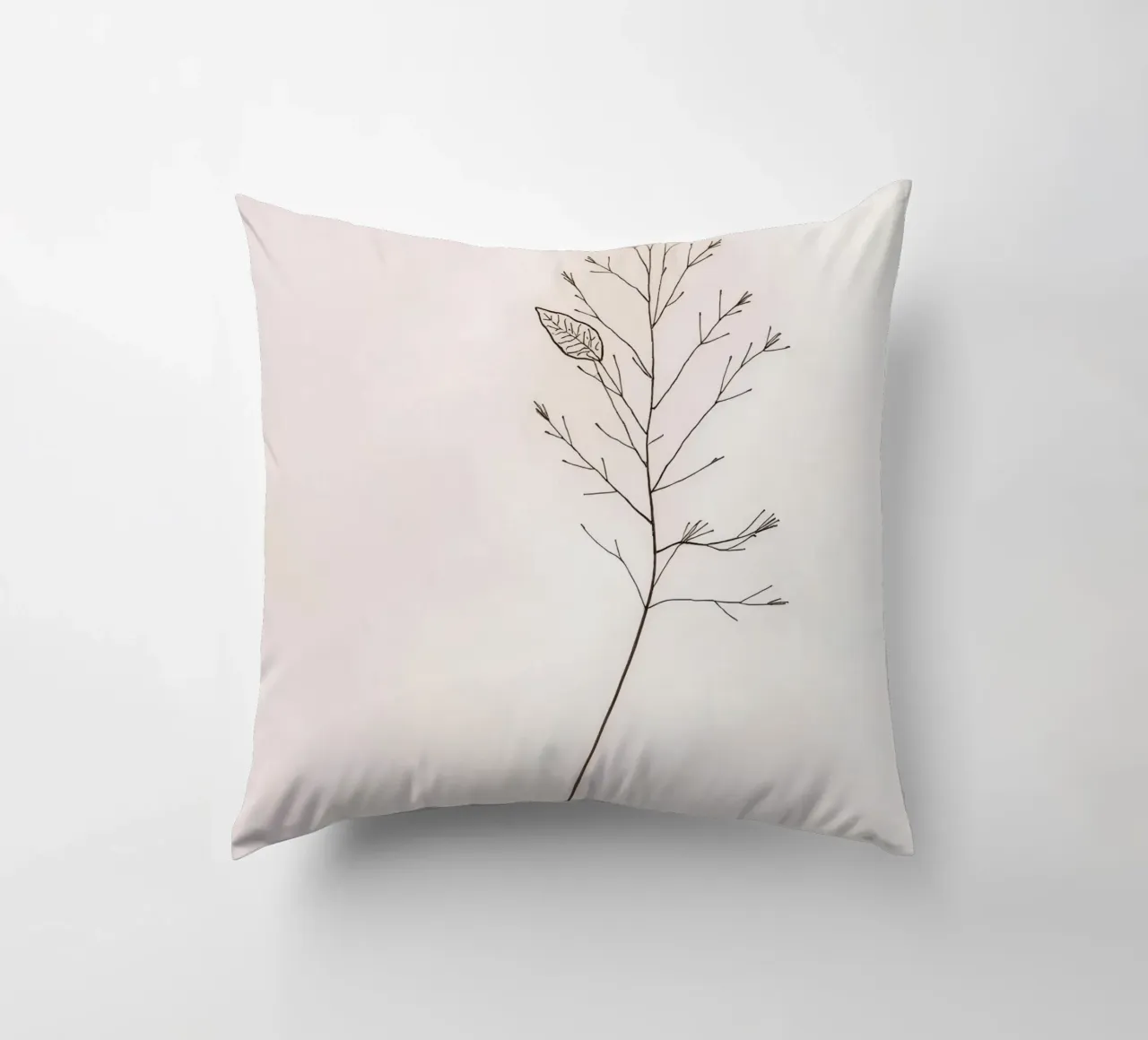 Single minimal botanical branch, displaying a leaf decorative cushion by DesignDoodle