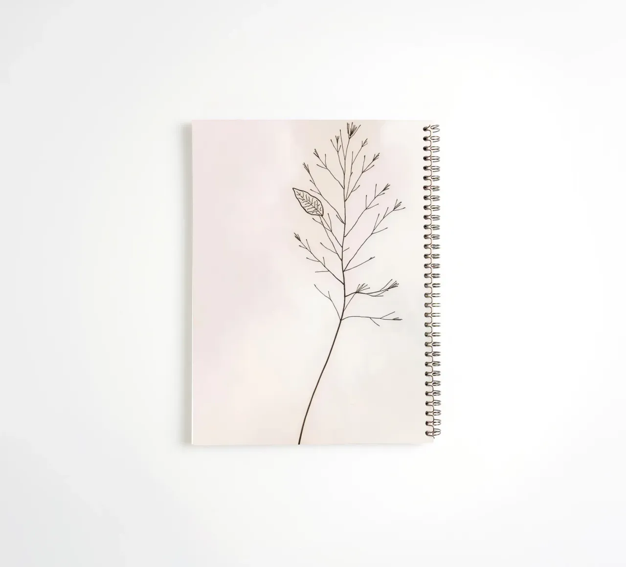 Single minimal botanical branch, displaying a leaf spiral notebook by DesignDoodle