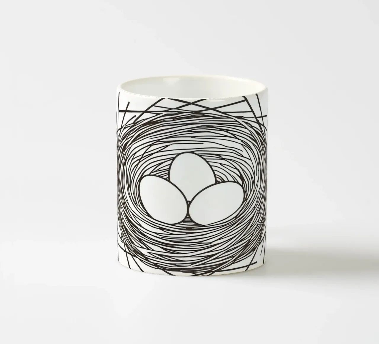 Nest containing three eggs depicted with line art ceramic mug by DesignDoodle