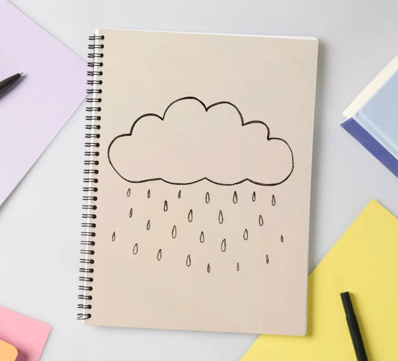 Simple sketch of a cloud with raindrops illustrating a rainy spiral notebook by DesignDoodle