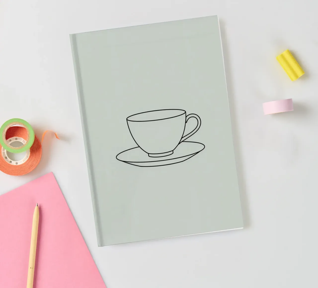 Semplice schizzo di una tazza da tè su un piattino esposto su un minimo diario da DesignDoodle