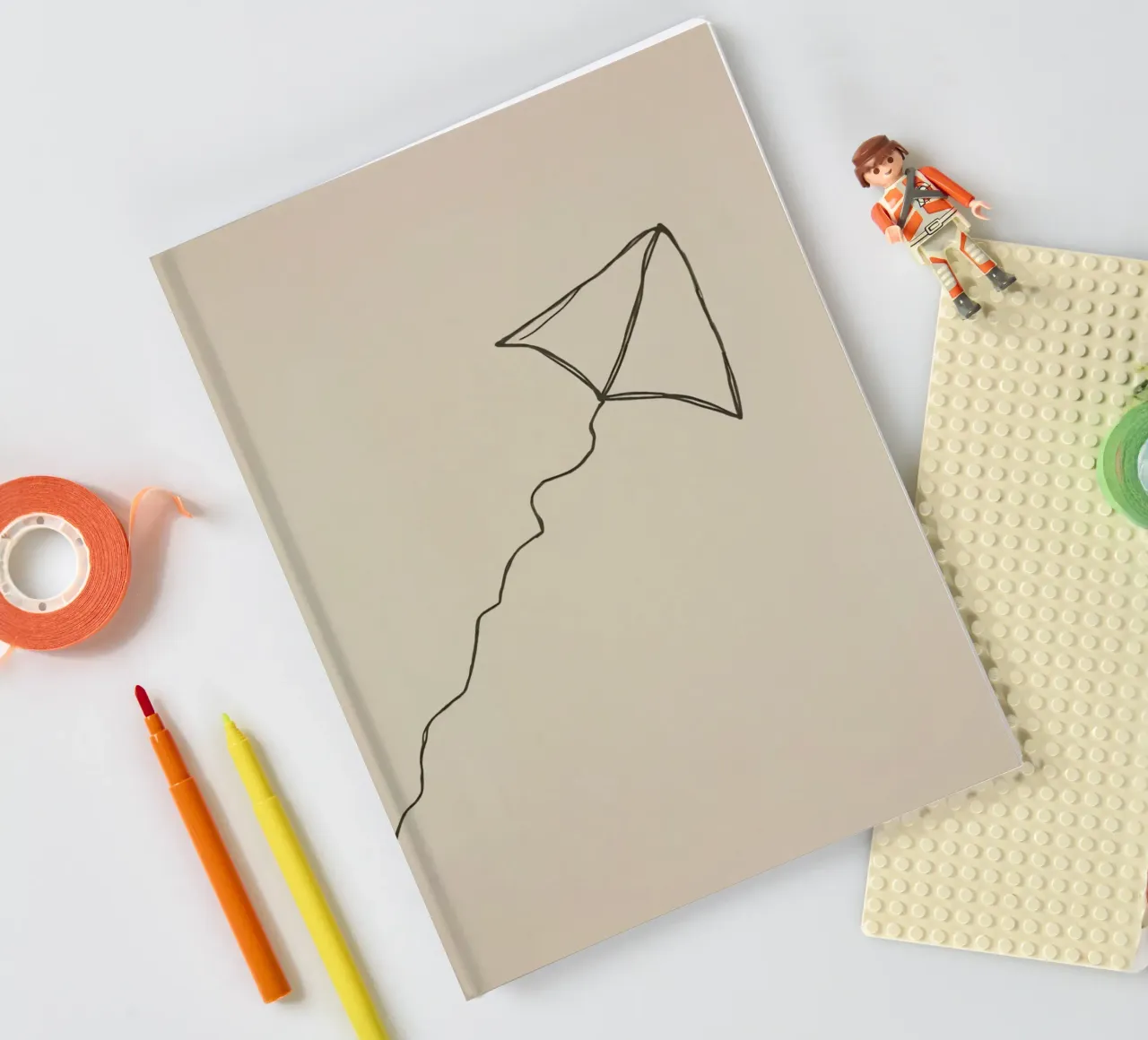 Aquilone che si libra in volo con una coda fluente attaccata, mostrando una gioiosa diario da DesignDoodle