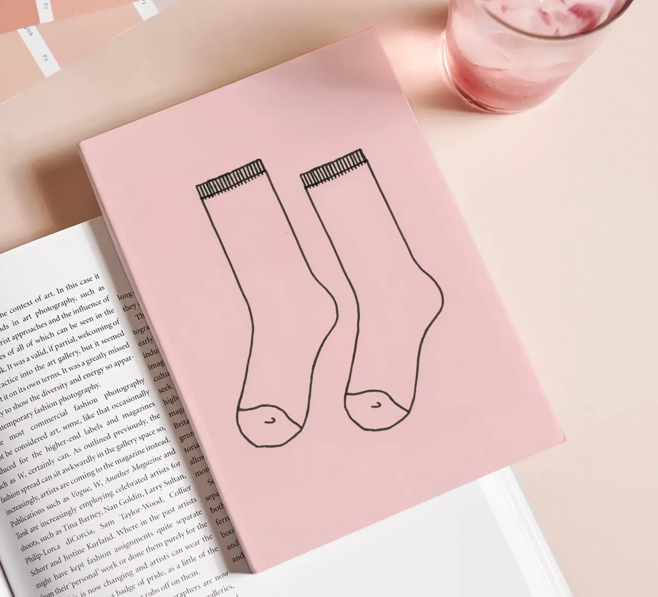 Simple design of a pair of socks with a pink background notebook by DesignDoodle