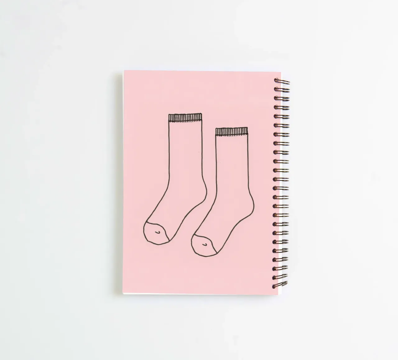 Simple design of a pair of socks with a pink background spiral notebook by DesignDoodle