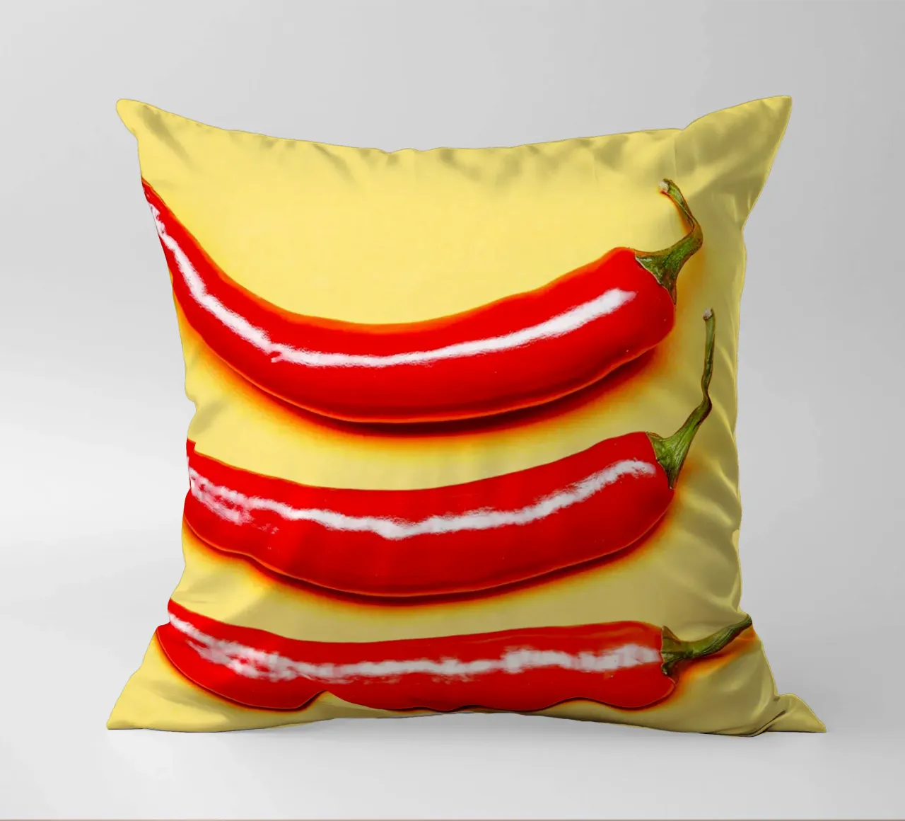 Red chilli peppers on a yellow surface decorative cushion by Bilderwelt - Kunst für die Wand