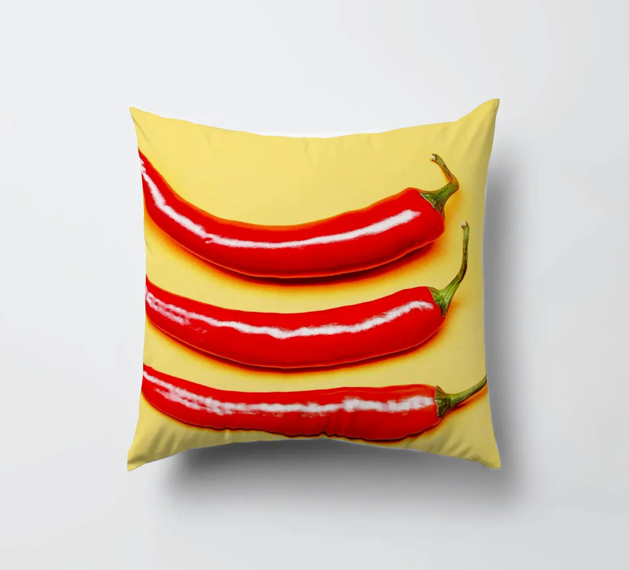 Red chilli peppers on a yellow surface decorative cushion by Bilderwelt - Kunst für die Wand