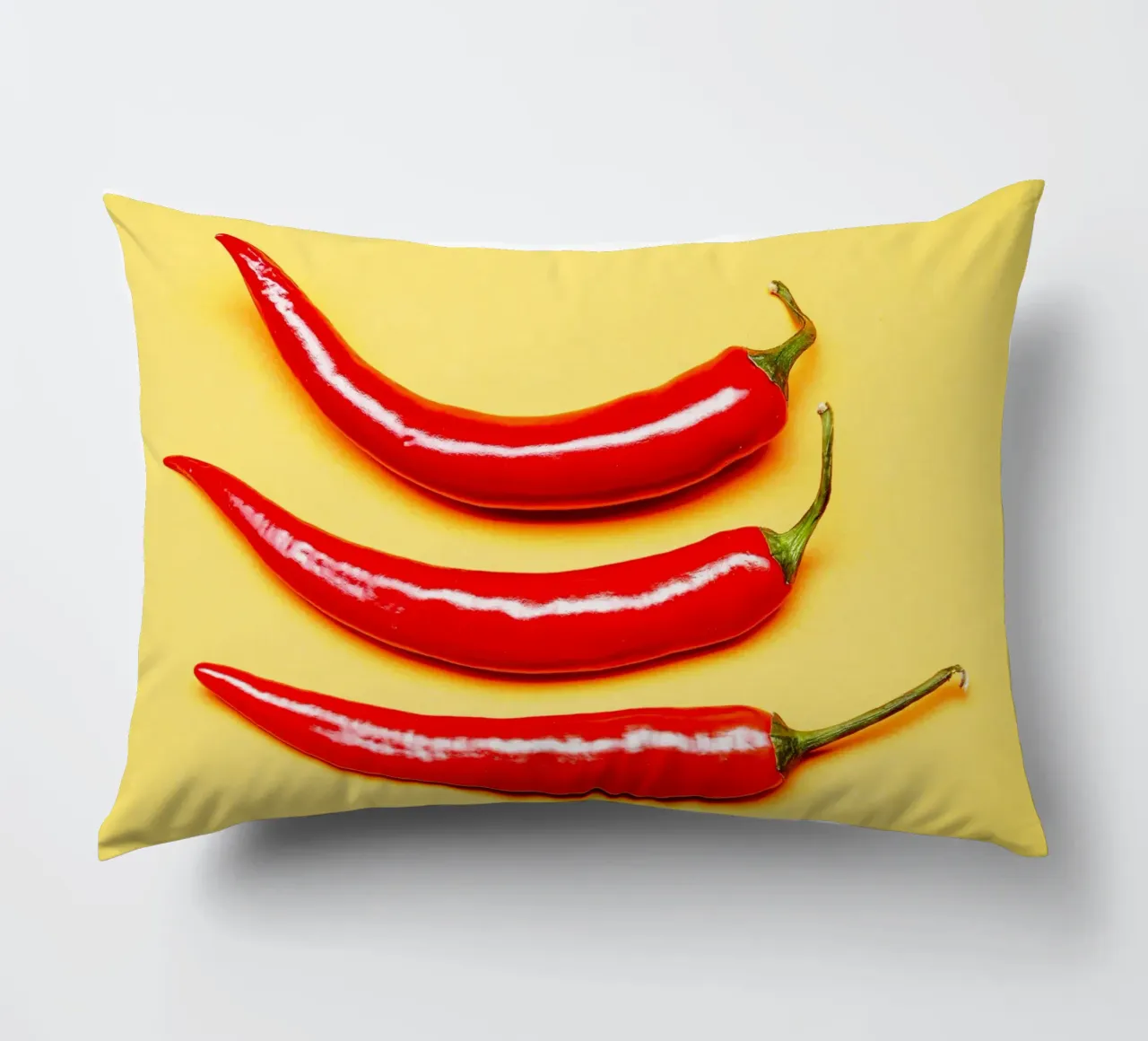 Red chilli peppers on a yellow surface decorative cushion by Bilderwelt - Kunst für die Wand