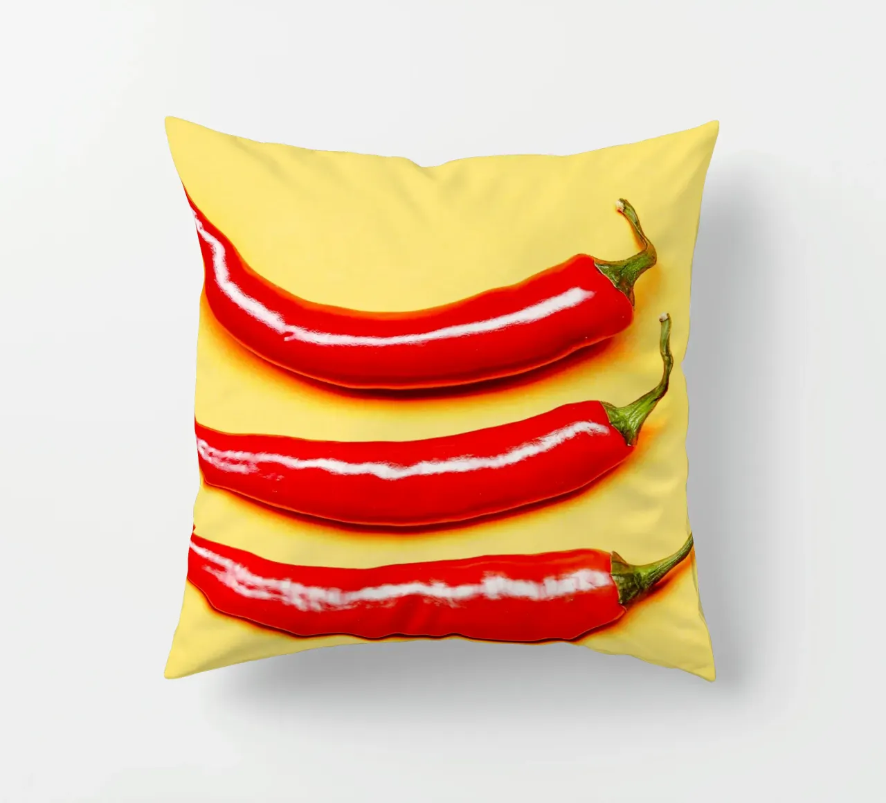 Red chilli peppers on a yellow surface decorative cushion by Bilderwelt - Kunst für die Wand