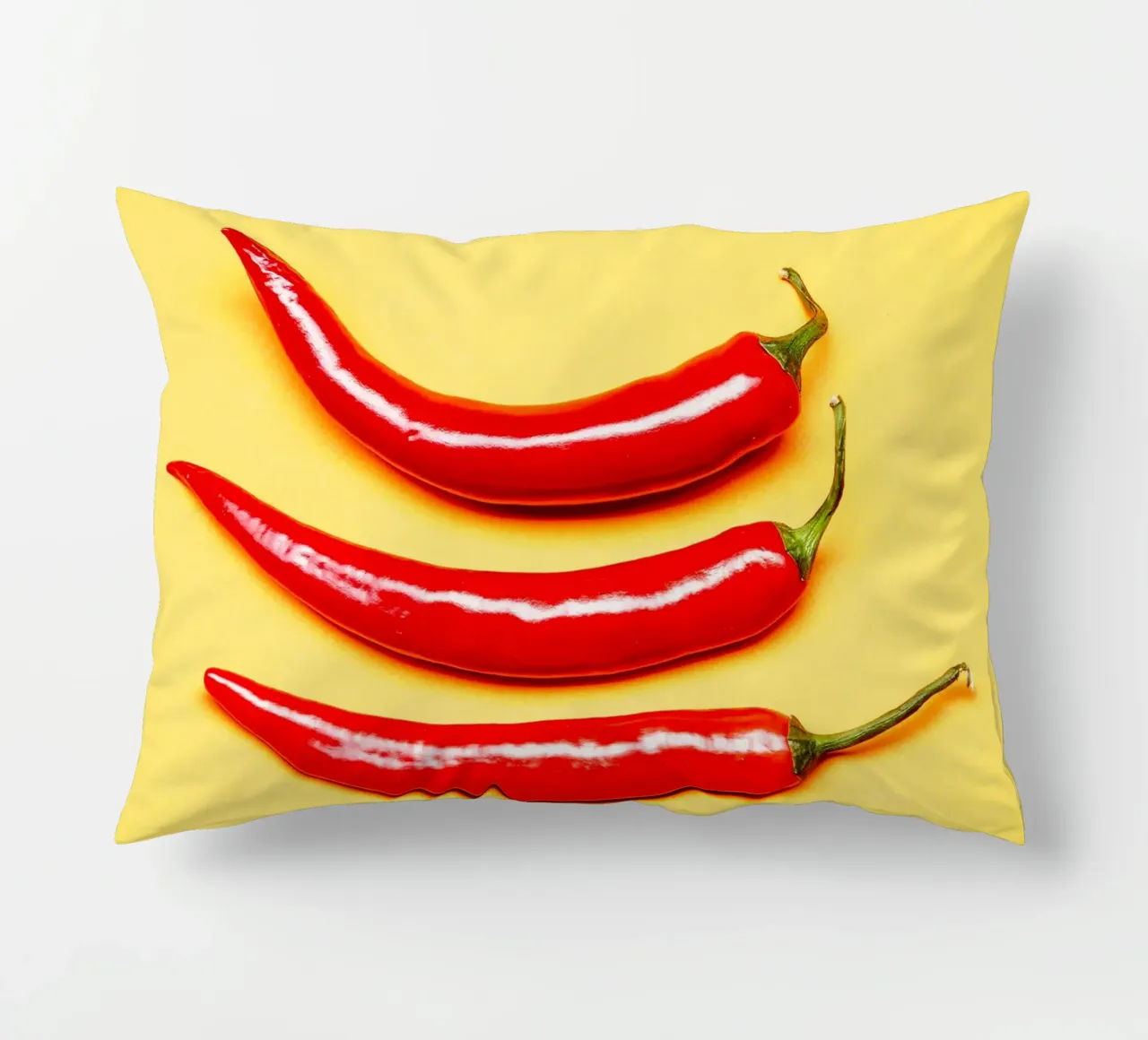Red chilli peppers on a yellow surface decorative cushion by Bilderwelt - Kunst für die Wand