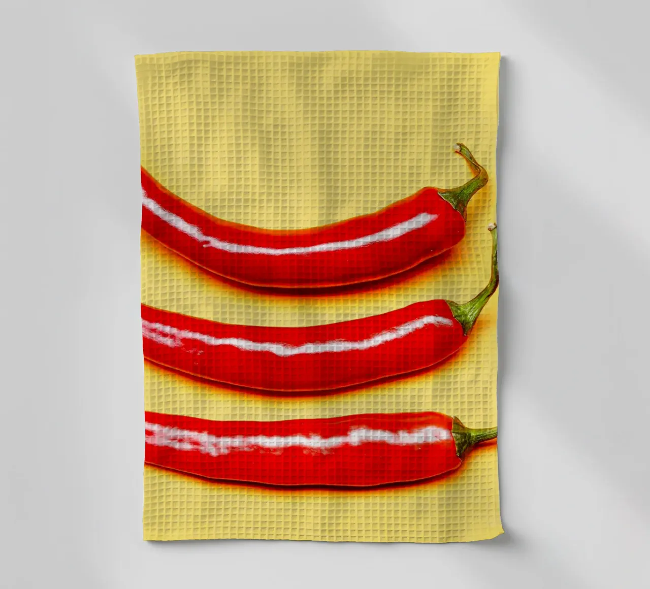 Piment rouge sur surface jaune torchon de Bilderwelt - Kunst für die Wand