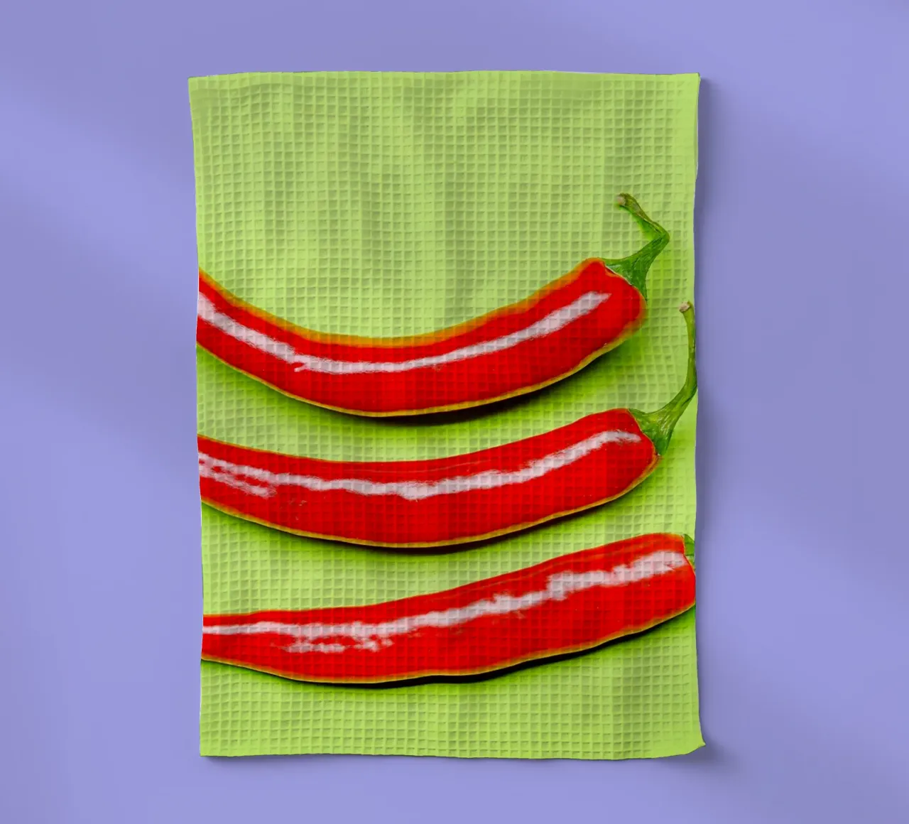 Drei rote Chilischoten auf grüner Fläche Geschirrtuch von Bilderwelt - Kunst für die Wand