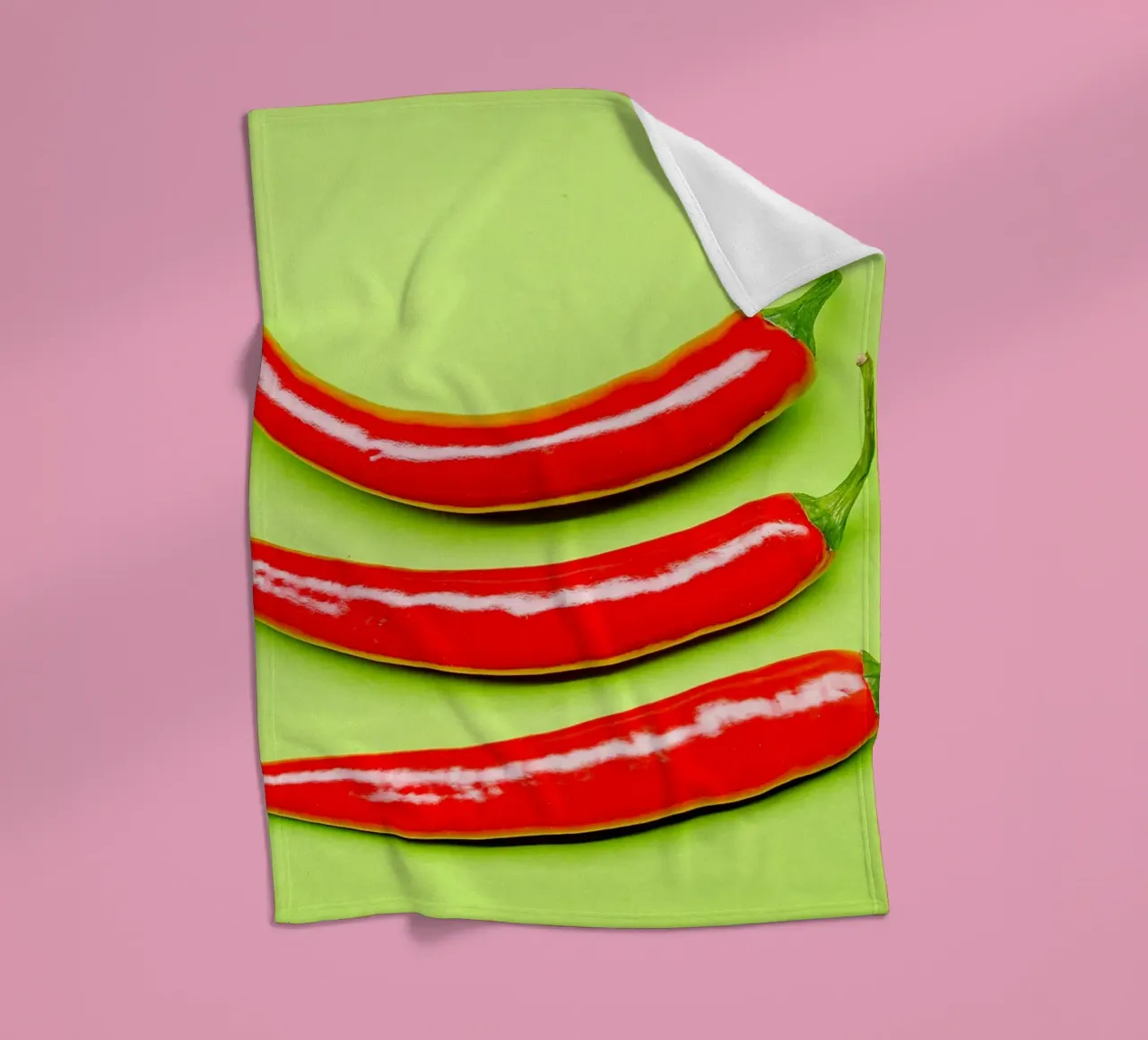 Three red chilli peppers on a green surface fleece blanket by Bilderwelt - Kunst für die Wand