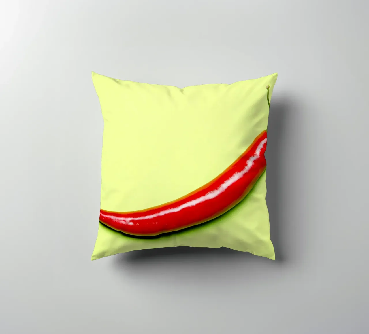 Red chilli pepper on a green background decorative cushion by Bilderwelt - Kunst für die Wand
