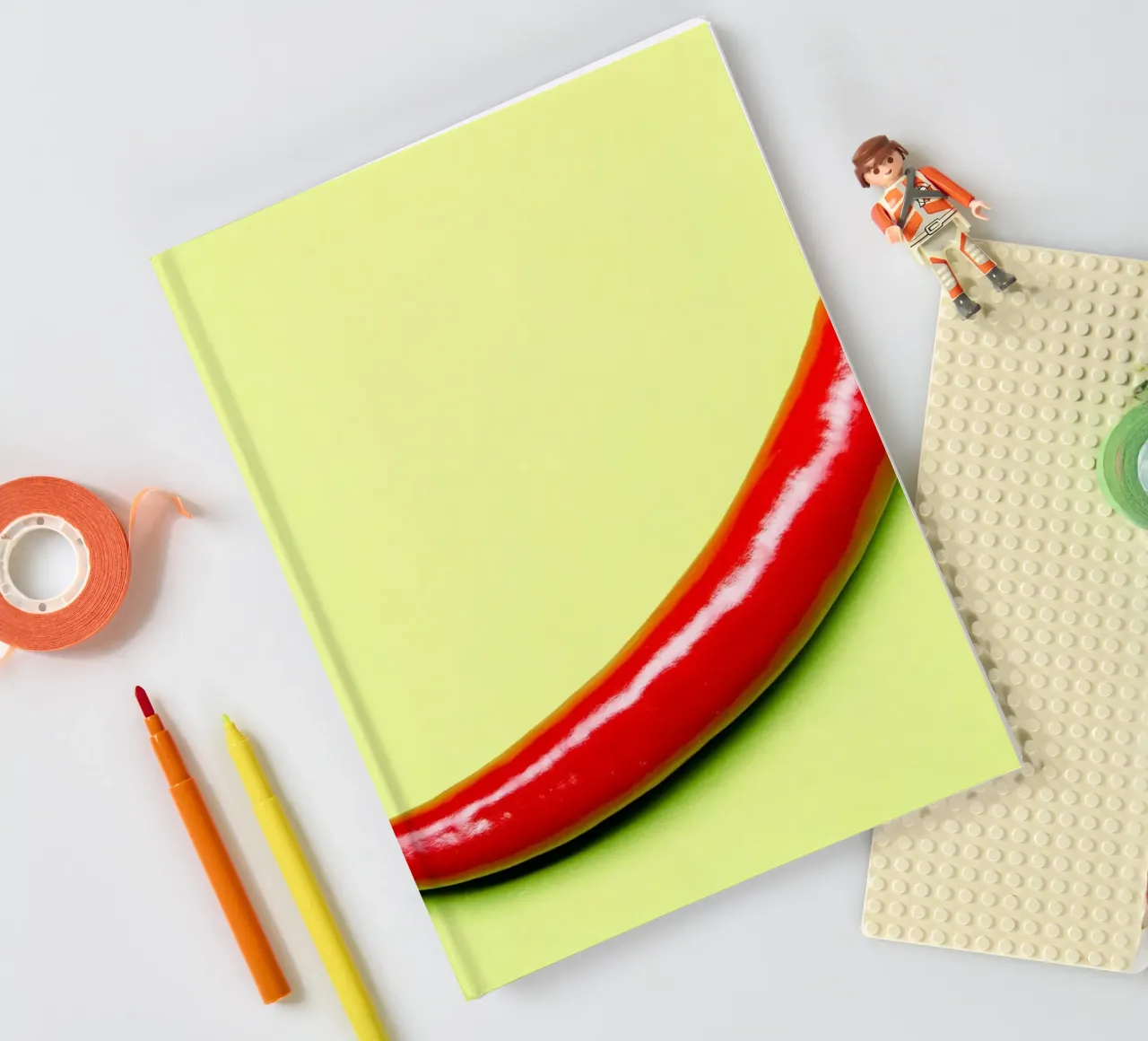 Red chilli pepper on a green background notebook by Bilderwelt - Kunst für die Wand