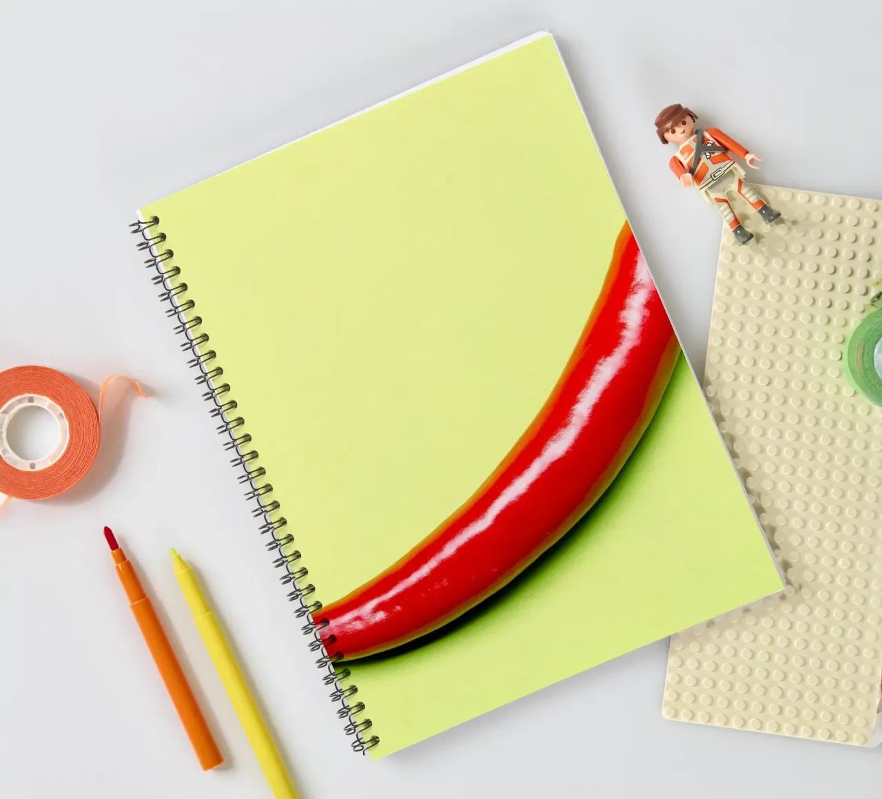 Red chilli pepper on a green background spiral notebook by Bilderwelt - Kunst für die Wand