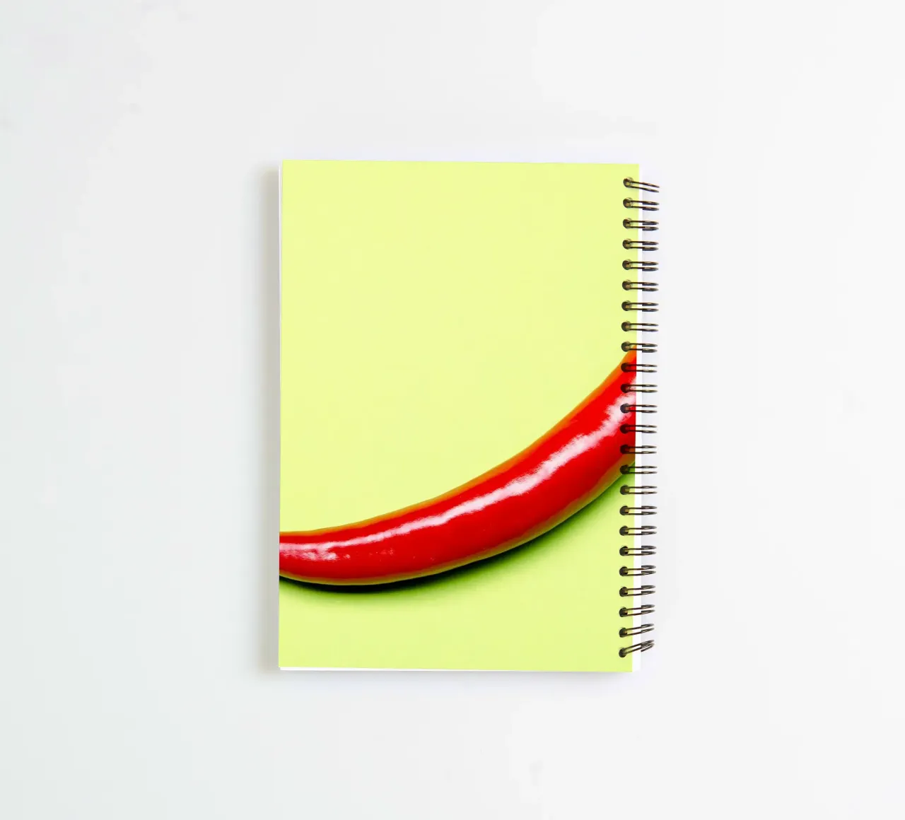 Red chilli pepper on a green background spiral notebook by Bilderwelt - Kunst für die Wand