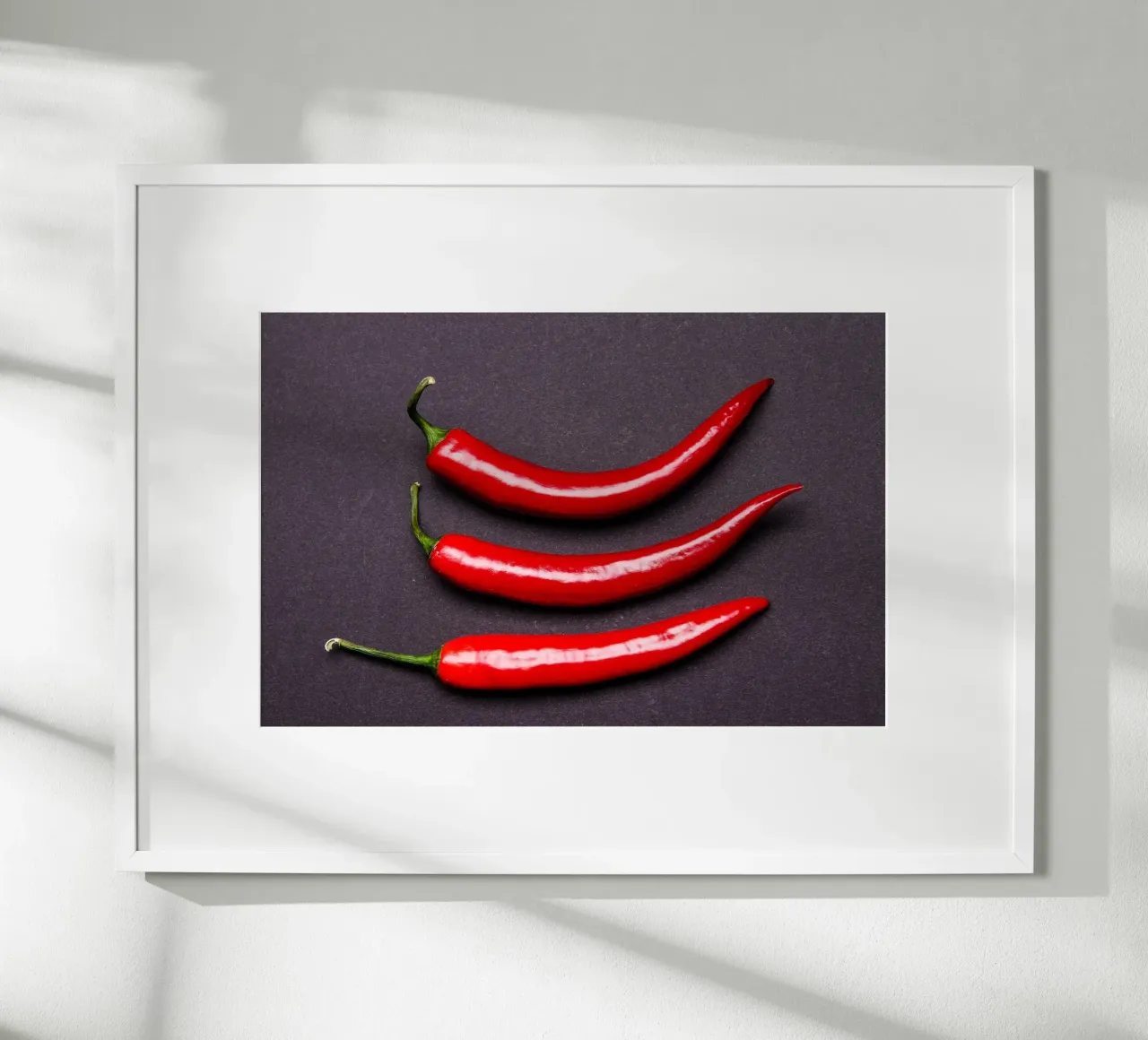Three chilli peppers on a black background hahnemühle by Bilderwelt - Kunst für die Wand