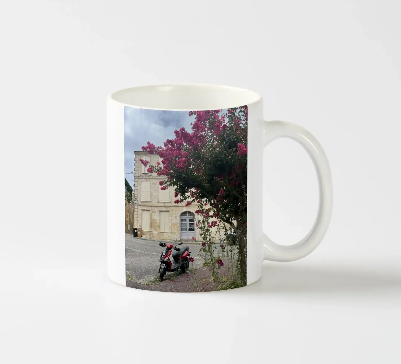 Motorbike in front of a beige house with a flowering shrub in France ceramic mug by Sous le ciel