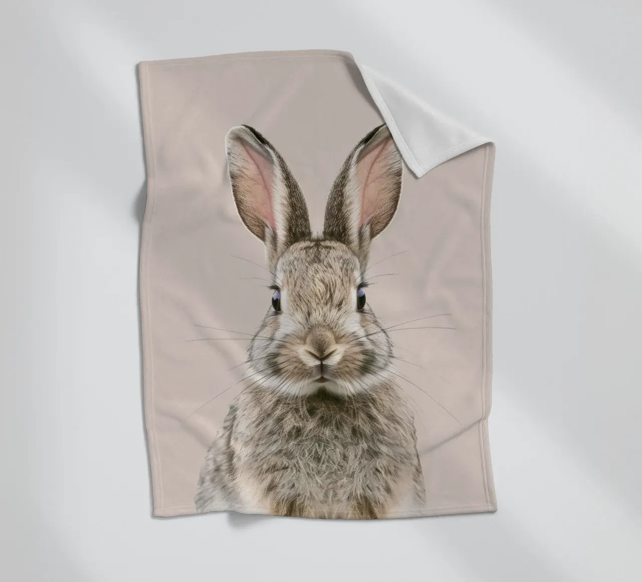 Fluffy rabbit with expressive eyes against a neutral art fleece blanket by DesignDoodle