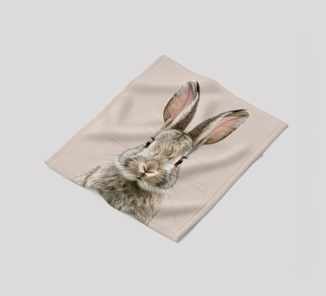 Fluffy rabbit with expressive eyes against a neutral art fleece blanket by DesignDoodle
