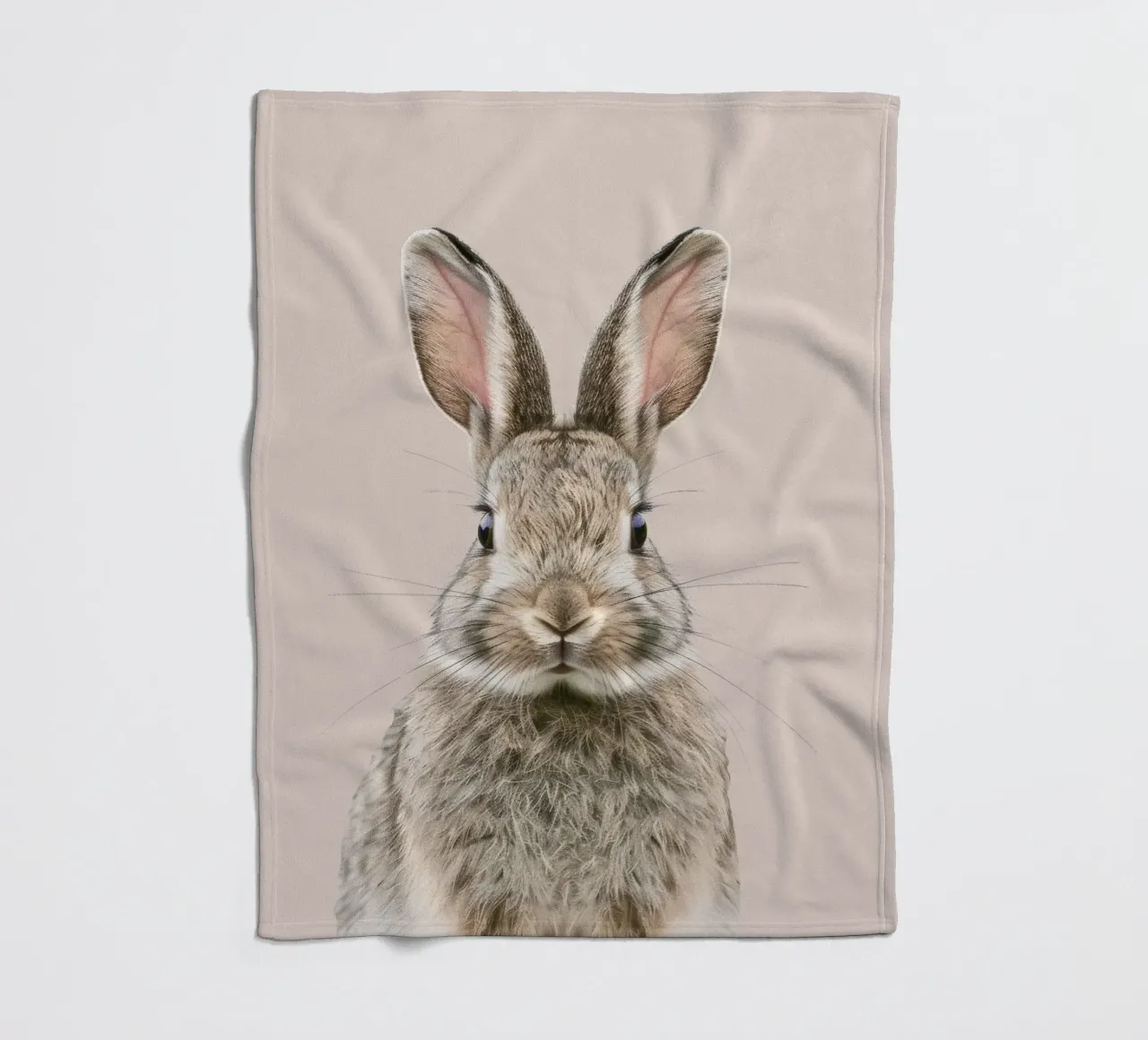 Fluffy rabbit with expressive eyes against a neutral art fleece blanket by DesignDoodle