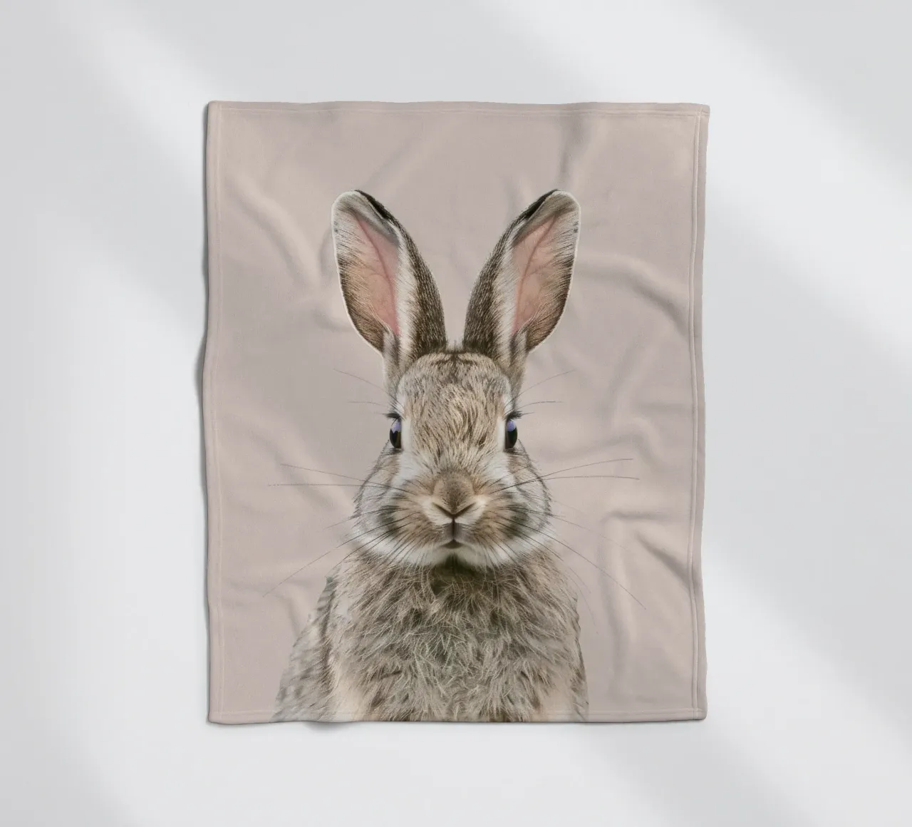 Fluffy rabbit with expressive eyes against a neutral art fleece blanket by DesignDoodle