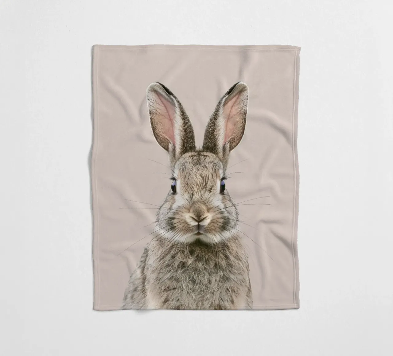 Fluffy rabbit with expressive eyes against a neutral art fleece blanket by DesignDoodle