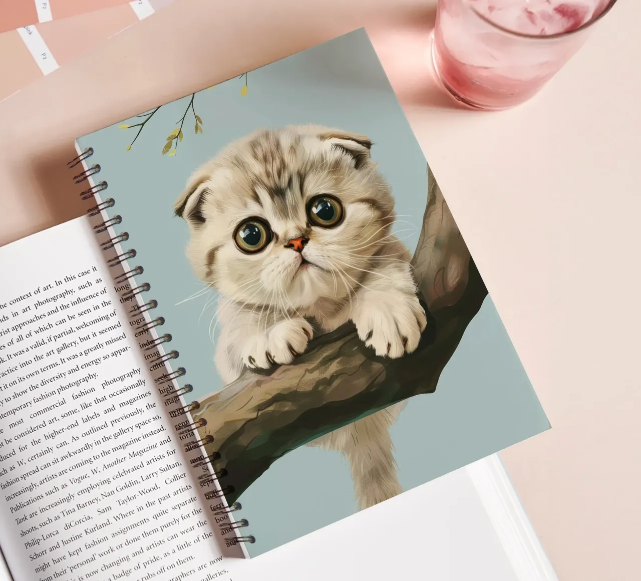 Cute kitten with glowing eyes climbing a branch in spring spiral notebook by DesignDoodle