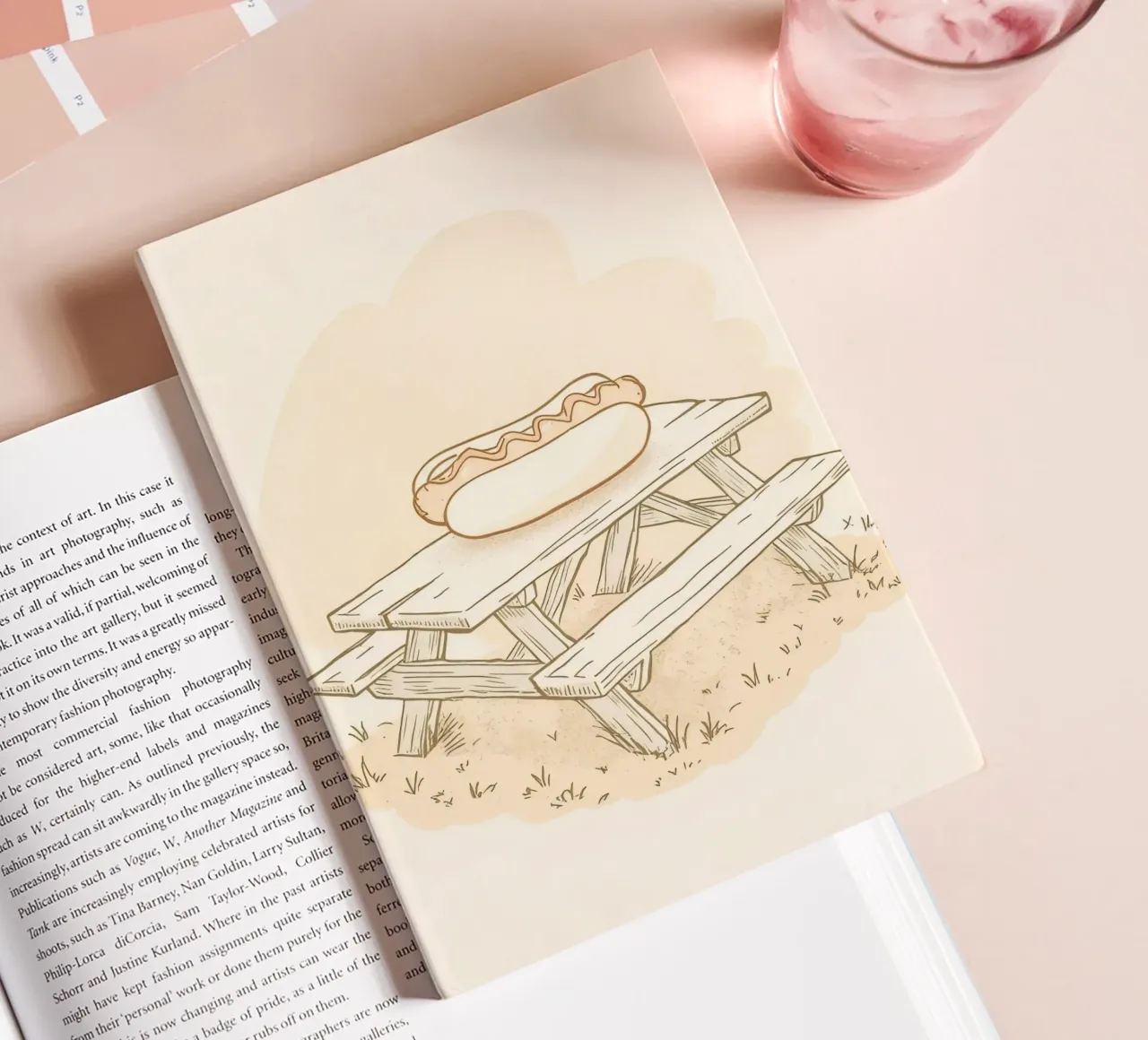 Hot dog resting on a wooden picnic table in a grassy field notebook by DesignDoodle