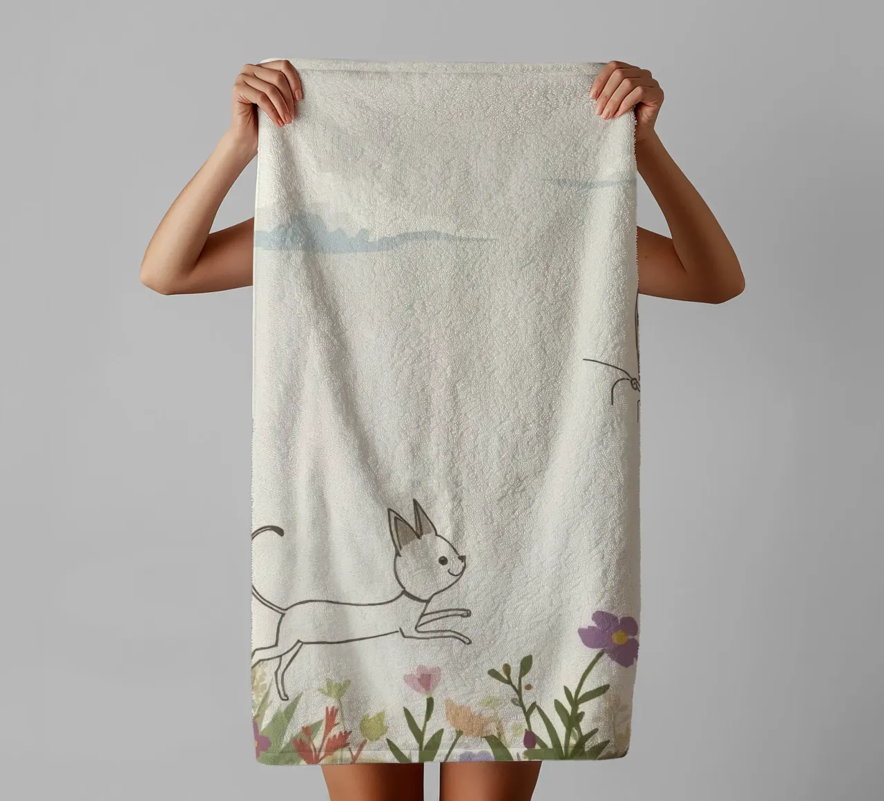Katze jagt Schmetterling in einer blühenden Wiese unter einem weichen Himmel Handtuch von DesignDoodle