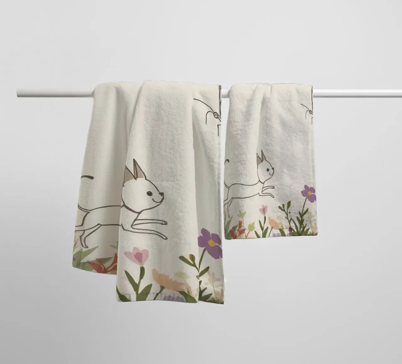 Katze jagt Schmetterling in einer blühenden Wiese unter einem weichen Himmel Handtuch von DesignDoodle