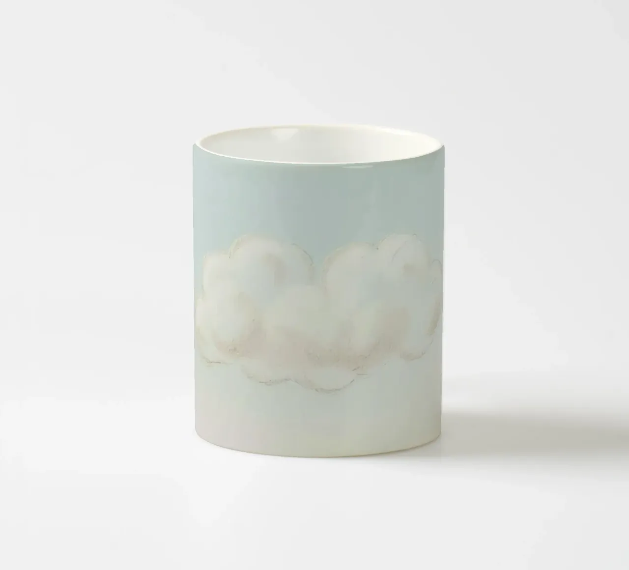 Una soffice nuvola bianca alla deriva in un cielo limpido sopra una terra serena tazza in ceramica da DesignDoodle