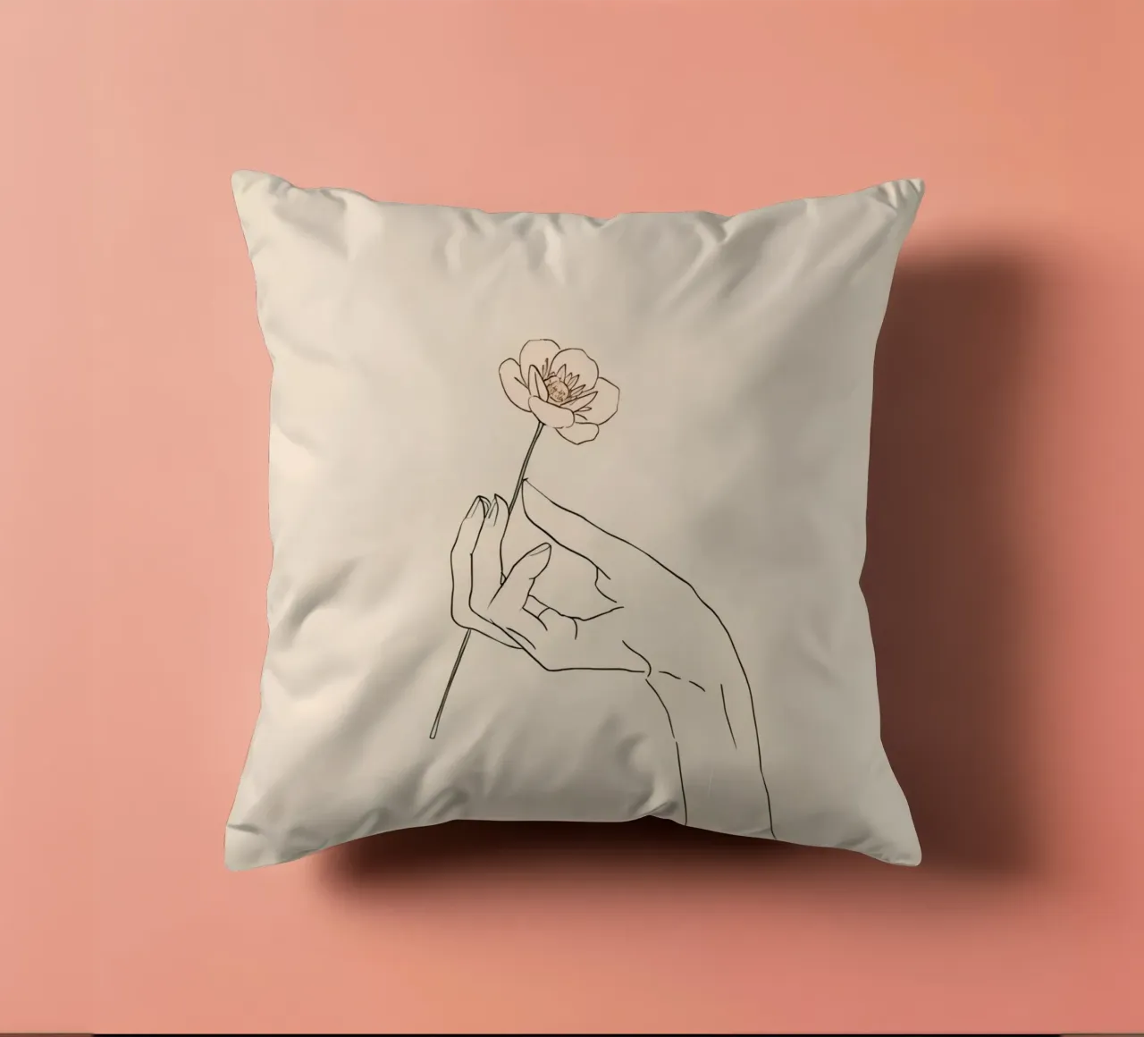 Elegant hand holding delicate flower against a soft beige decorative cushion by DesignDoodle