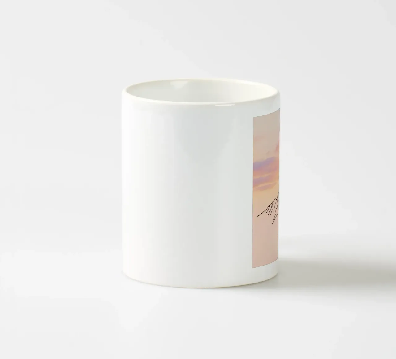 Silhouette di montagna contro un cielo pastello all'alba tazza in ceramica da DesignDoodle