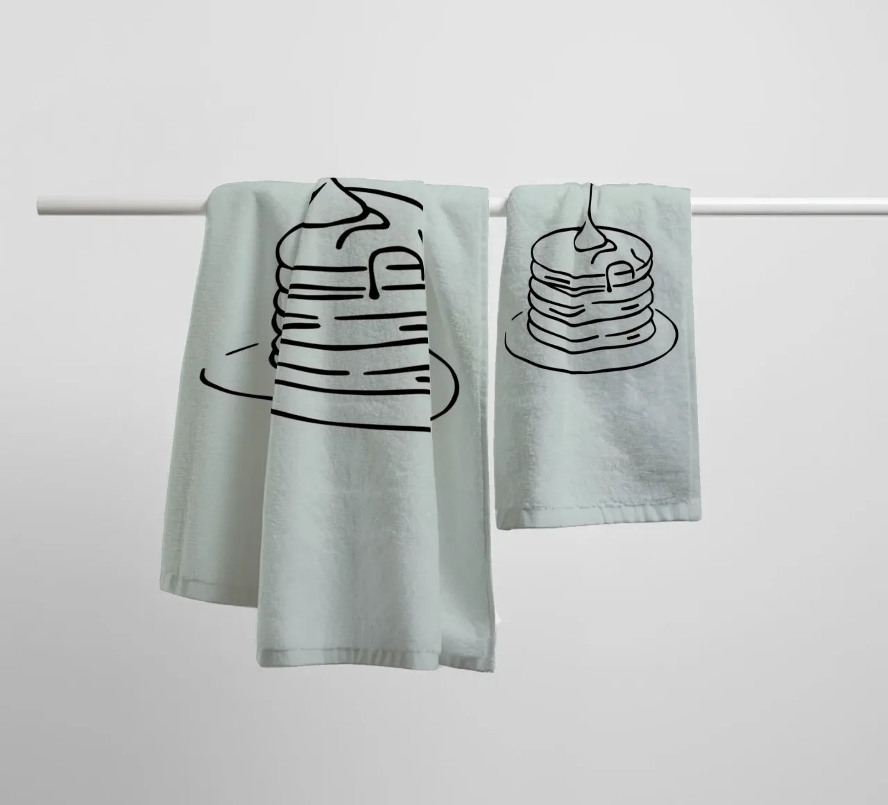 Stacked pancakes with syrup dripping on a green background towel by DesignDoodle